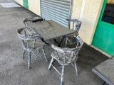 a table and chairs outside of a building with a green door