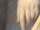 portrait of a man in a black coat with a white hand holding a blue cloth