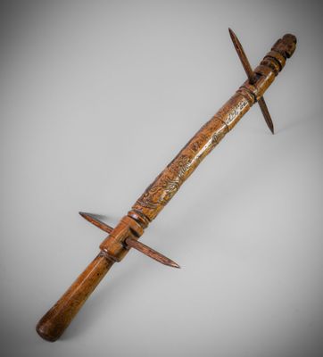 un gros plan d'un couteau en bois posé sur une surface blanche