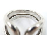 silver ring with two inter links on a white surface