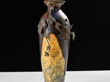 un vase avec un oiseau posé sur une table