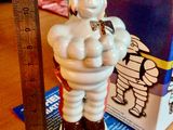 une figurine représentant un homme tenant une batte de baseball à côté d'une règle
