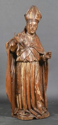wooden statue of a man in a robe and hat holding a cane