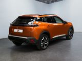 an orange car is parked in a large room with a white wall