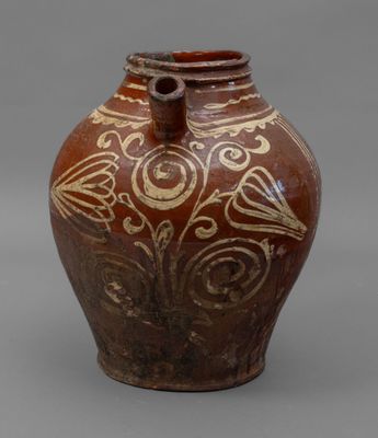 an old brown vase sitting on top of a gray surface