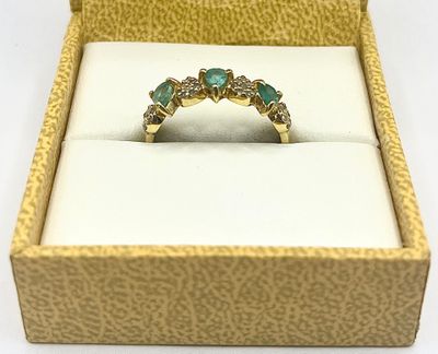 an image of a diamond and emerald ring in a box