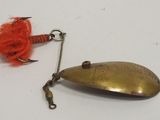 a fishing lure and a fishing hook on a white surface