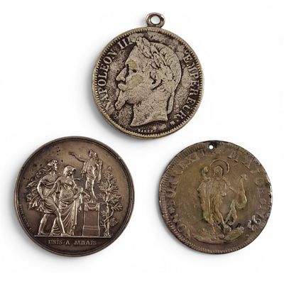 trois pièces de monnaie anciennes sont exposées sur un fond blanc