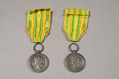two medals with a ribbon and a medal on a table