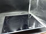 une plaque de cuisson noire surmontée d'un brûleur noir