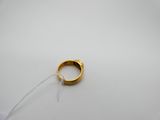 gros plan d'une bague en or sur une surface blanche