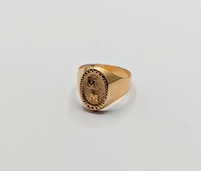 a gold signet ring with an image of a lion on it