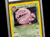 La carte Pokémon se trouve dans un étui en plastique transparent sur fond noir.
