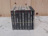 six magnétoscopes VHS sont empilés les uns sur les autres devant un mur en bois