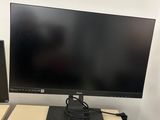 a computer monitor, keyboard and speakers on a desk