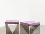 two purple stools sitting on top of each other in a room