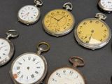 many different types of pocket watches on the table