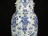 a blue and white vase sitting on a black surface