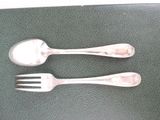 two silver spoons and a fork on a table