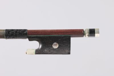 a close up of a violin bow on a white surface