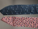 three ties with different designs are hanging on a wall