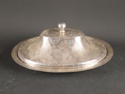 an antique silver plate with a domed lid on a black surface