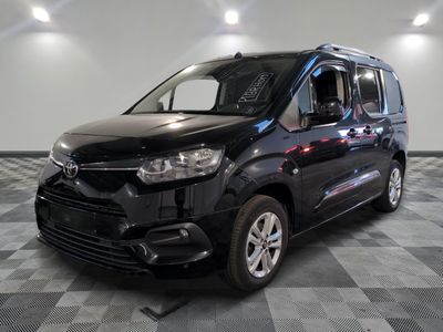 la photo d'une camionnette noire garée sur un sol en damier