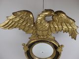 a clock with an eagle on it hanging on a wall