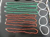 many necklaces and bracelets laid out on a table
