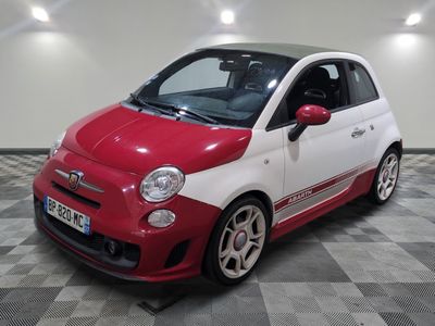 une petite voiture rouge et blanche garée sur un sol en damier