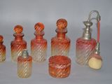 several glass bottles and a faucet are lined up on a white surface
