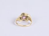 a close up of a gold ring with a pink stone
