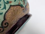 a close up of a vase on a white surface