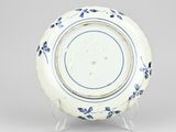 blue and white plate with blue flowers on it on a stand