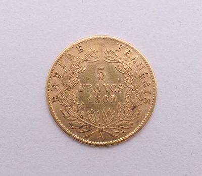gros plan d'une pièce d'or sur une surface blanche