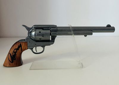 pistolet posé sur un socle en acrylique transparent, sur une surface blanche