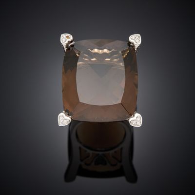 a close up of a ring with a large brown diamond