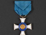 a blue and silver medal with a cross on it