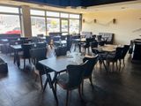 tables and chairs are set up in a restaurant with a view of the street