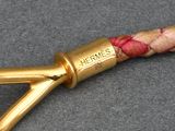 a close up of a gold colored umbrella handle on a gray surface