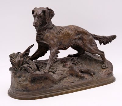 bronze statue of a dog on a rock with a bird in it ' s mouth