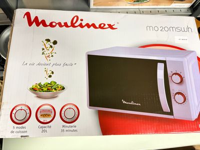 une boîte posée sur une table, sur laquelle se trouve un micro-ondes