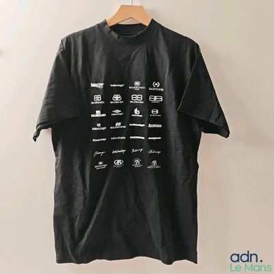 un t-shirt noir avec une inscription blanche, suspendu à un cintre