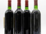 three bottles of wine are lined up on a white surface