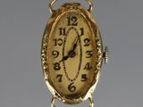 a gold clock hanging from the side of a wall