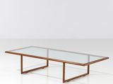 une table basse avec un plateau en verre posée sur un piètement blanc