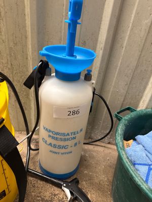 un vaporisateur bleu et blanc posé à côté d'un seau jaune et noir