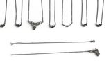 several different types of pins and needles are arranged on a white surface