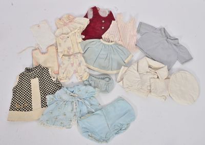 beaucoup de vêtements de bébé posés sur une surface blanche