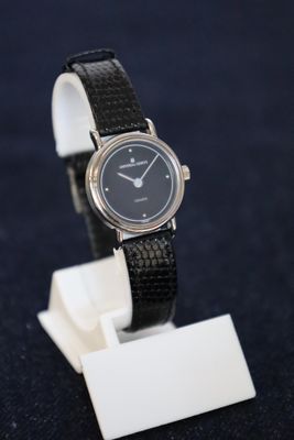 une montre posée sur un support sur une table